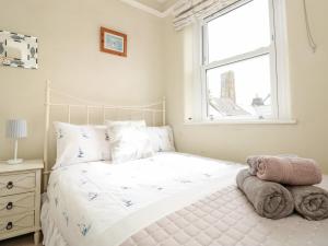 uma cama branca num quarto com uma janela em Driftwood em Dartmouth