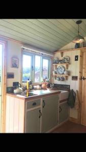 una pequeña cocina con fregadero y ventana en Steam and Stars Luxury Glamping en Williton