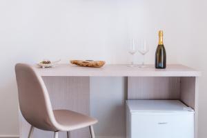 a white table with a chair and a bottle of wine at Pandora Rooms - Pompei - Central Pompeii Near the Ruins in Pompei