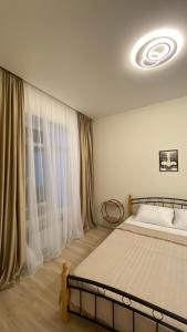 a bedroom with a bed and a large window at Your Sweet Home Gyumri in Gyumri
