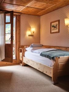 een slaapkamer met een bed in een kamer met een raam bij Hotel Chesa Grischuna in Klosters