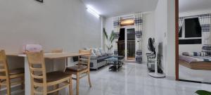 a kitchen and living room with a table and chairs at Căn Hộ Homestay Ninh Thuận-Heri24h in Kinh Dinh