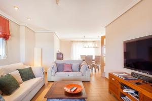 ein Wohnzimmer mit einem Sofa und einem TV in der Unterkunft Casa en Valencia, cerca de golf, playas, moto Gp in Valencia