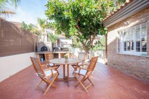 a table and chairs on a patio with a tree at Casa en Valencia, cerca de golf, playas, moto Gp in Valencia