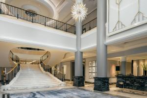 a lobby with a staircase and a chandelier at The Ritz-Carlton, Berlin in Berlin