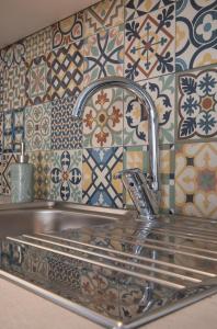 a sink in a kitchen with tiles on the wall at Osiris - cozy sea walk lodge with private garden in Nea Makri
