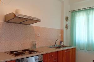 a kitchen with a sink and a stove and a window at Mirto’s House in Tripótama