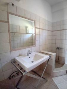 a white bathroom with a sink and a mirror at Mirto’s House 