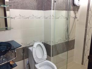 a bathroom with a toilet and a glass shower at Junior Apartment in Pattaya