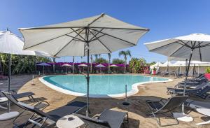 una piscina con sillas y sombrillas en Albatros Hotel, en Siracusa