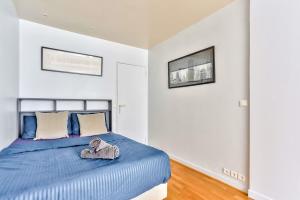 a bedroom with a bed with a stuffed elephant on it at Appartement Quartier Arc de Triomphe Free Netflix in Paris