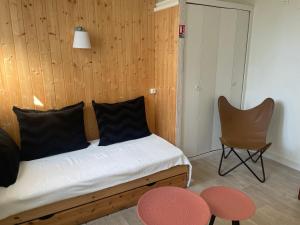 a bedroom with a bed and a chair and a table at Hotel Regina in Saint-Nectaire