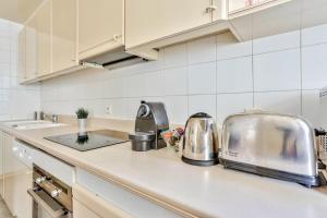 a kitchen with a counter top with a toaster at Appartement Quartier Arc de Triomphe Free Netflix in Paris