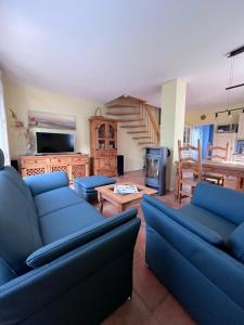 a living room with blue couches and a fireplace at Uns Muschelhus in Zingst