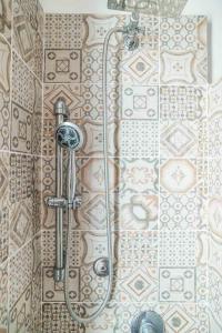y baño con ducha y pared de azulejos. en CASA AMEDEO al PORTO ANTICO- Acquario - Centro storico en Génova
