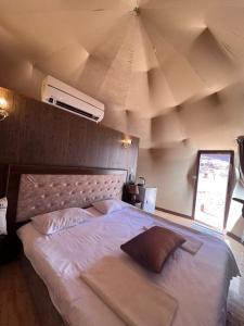 a bedroom with a large white bed with a ceiling at Bubble camp 2 in Wadi Rum