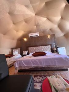 a bedroom with a large bed with a wooden ceiling at Bubble camp 2 in Wadi Rum