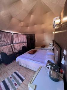 a bedroom with two beds in a room with a ceiling at Bubble camp 2 in Wadi Rum