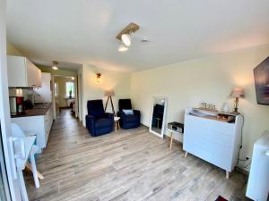 a living room with blue chairs and a kitchen at Am Oland 11 Bungalow in Büsum