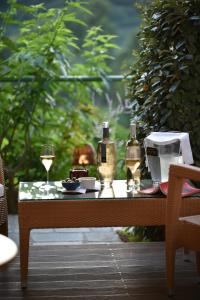a table with two glasses and wine bottles on it at Hôtel Alivi Di Santa Giulia in Porto-Vecchio