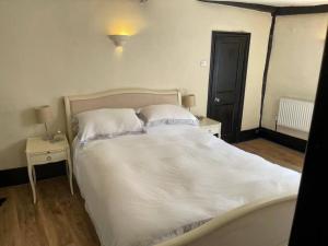 1 cama con sábanas blancas y almohadas en una habitación en SmithStayz Apartments Epping en Epping