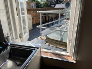 a kitchen with a sink and a view of a balcony at SmithStayz Apartments Epping in Epping +7 photos