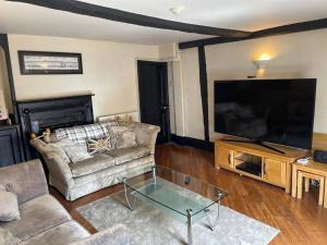 a living room with a couch and a large flat screen tv at SmithStayz Apartments Epping in Epping