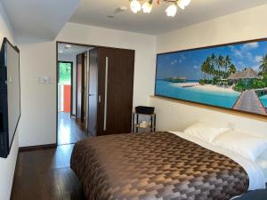 ein Schlafzimmer mit einem Bett und einem großen Wandgemälde in der Unterkunft Ao-Ao-Hotel - Vacation STAY 32070v in Nago