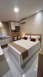 ein Schlafzimmer mit einem großen weißen Bett in einem Zimmer in der Unterkunft Suíte ACONCHEGO no Villa do porto a 300m do Beach Park e a 5 minutos a pé da praia in Aquiraz