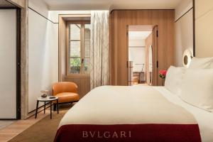 a hotel room with a bed and a chair at Bulgari Hotel Roma in Rome
