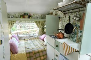 cocina pequeña con cama y fogones en Steam and Stars Luxury Glamping, en Williton