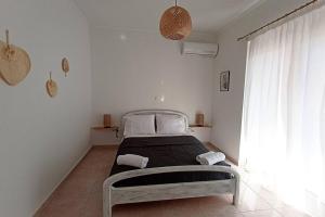 a white bedroom with a bed in a room at Bougainvillea apartment in Zakynthos