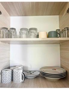 a shelf with plates and cups and dishes on it at Зелёный двор in K'obulet'i