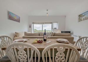 a dining room with a table and chairs and a couch at Bayview Apartment - Machynys in Llanelli