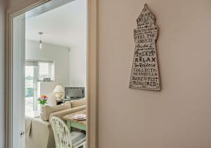 a door to a living room with a sign on the wall at Bayview Apartment - Machynys in Llanelli