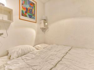 uma cama não feita num quarto branco com uma pintura em Appartement Gourette, 2 pièces, 6 personnes - FR-1-400-51 em Gourette