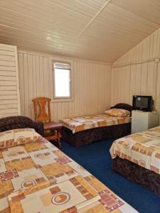 a room with three beds and a tv in it at Harmony Villa in Costinesti