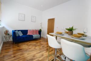 a living room with a blue couch and a table at Stunning Central City Apartment in Nottingham