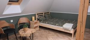a small bedroom with a bed and a table at Zacisze Arturówka in Laskowa