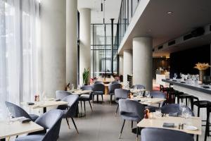 a dining room with tables and chairs and a restaurant at Midnight Hotel, Autograph Collection in Canberra