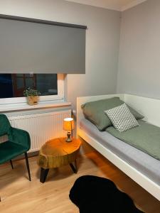 ein Schlafzimmer mit einem Bett, einem Stuhl und einem Tisch in der Unterkunft Szmaragdowy domek in Nowy Wiśnicz
