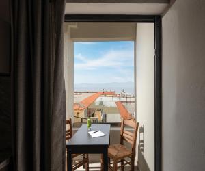 a balcony with a table and chairs and a window at Erifili at Sarti Beach Apartments & Studios in Sarti