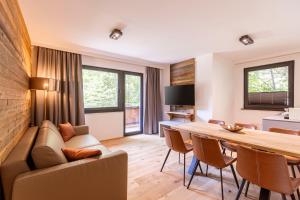 Saalbach Suites by ALPS RESORTS في سالباخ هينترغليم: غرفة معيشة مع أريكة وطاولة