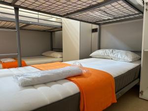 - une chambre avec 2 lits superposés et une couverture orange dans l'établissement Vigo Beds & Rooms, à Vigo