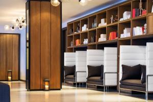 a salon with white chairs and shelves with books at Le Meridien Atlanta Perimeter in Atlanta