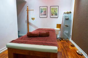 a bedroom with a bed with red sheets and pillows at Perła Bieszczadów - Domki in Czarna +26 photos