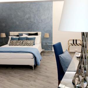 a bedroom with a bed with blue and white pillows at Soggiorno La Coccinella in Florence