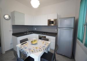 una pequeña cocina con mesa y nevera en Casa San Martino, en Leverano