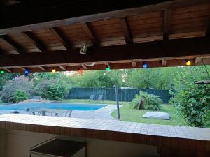 uma vista para um quintal com uma piscina e uma pérgola em Bellevue em Lamagistère