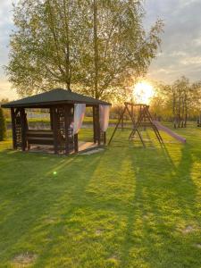 a park with two play structures in the grass at Szmaragdowy domek in Nowy Wiśnicz